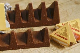 In this photo illustration two bars of the Toblerone Swiss chocolate are shown, at front is the new style 150 gram bar showing the reduction in triangular pieces, in the background is the older style 360 gram bar, pictured in London, Tuesday, Nov. 8, 2016. More valleys, fewer chocolate peaks: The maker of Toblerone Swiss chocolate says it's widened the spaces in its iconic, triangle-array bars for some discount shops in Britain to keep prices down. Mondelez International says the move aims to meet pricing targets by customer Poundland and other discount retailers, and has nothing to do with Britain's vote to leave the European Union.