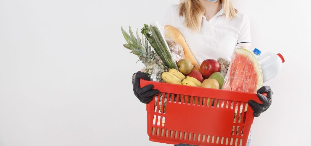 woman holding basket of groceries
