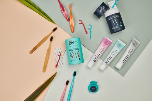 Grin product range flat lay, dental floss, toothbrushes and toothpaste