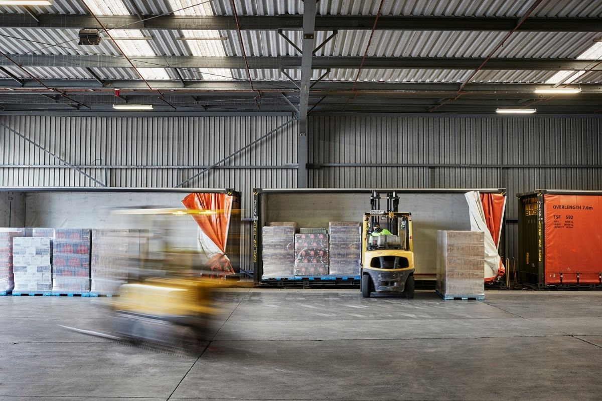 Forklift moving through a Coca-Cola warehouse